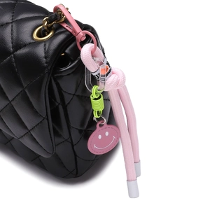 Borsa a tracolla trapuntata nera con ciondolo intrecciato sorridente e dettagli dorati