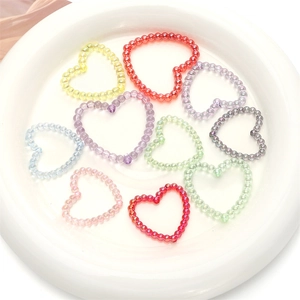 Macro-opname van kleurrijke iriserende acryl hartkralen in een witte keramische schaal