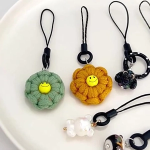 Handgefertigte Schlüsselanhänger mit Blumen- und Bärenmotiven auf einem weißen Keramikteller