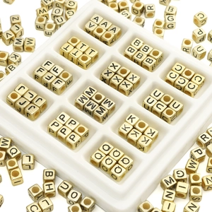 Close-up of golden square 6mm acrylic alphabet beads with black uppercase letters for DIY jewelry