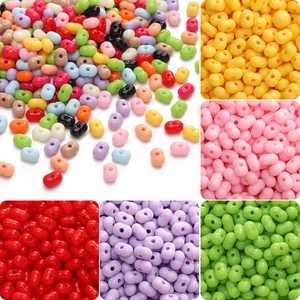 Dettaglio macro di perle a forma di arachide in acrilico 8x5mm con doppio foro per DIY
