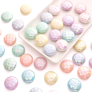 Macro detail of acrylic tulip flower beads and checkered round charms for DIY jewelry