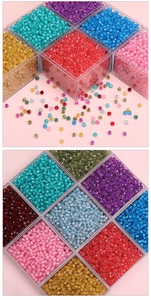 Macro view of multi-color faceted 4mm glass beads in a clear plastic storage box