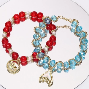 Detail von Perlenarmbändern mit roten Crackle-Perlen und blauen Kristall-Fischschwanz-Anhängern