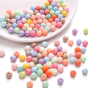 Macro detail of mixed macaron colored matte acrylic round beads with holes for DIY jewelry