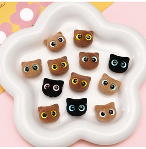 Close-up of cute flocked cat head beads in colorful assorted tones for DIY jewelry making