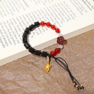 Primer plano de una pulsera artesanal de cuentas de madera 8x8mm con colgante dorado de suerte
