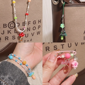 Gros plan de pendentifs champignons en verre colorés sur colliers et bracelets DIY faits main