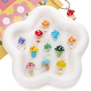 Gros plan de pendentifs champignons en verre coloré faits main pour bijoux DIY en plat
