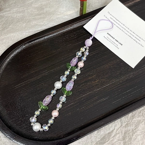 Detailed macro view of handmade acrylic tulip beads with pearls on a purple lanyard