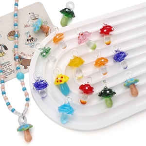 Pendentifs champignons en verre 15x26mm pour bijoux DIY présentés sur un plateau en céramique