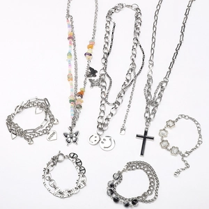 Détail d'ensemble de bijoux argentés avec perles papillon et breloques cœur gravées MOM