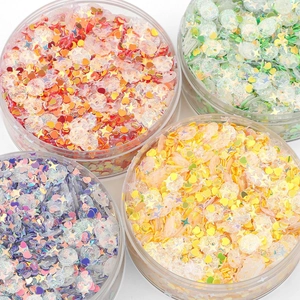Close-up of mixed heart and star sequins in clear containers for DIY jewelry making