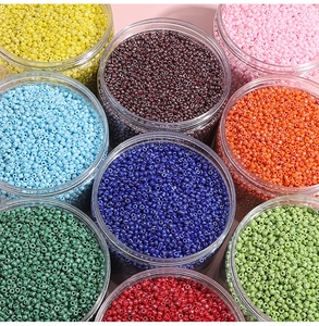 Vue macro de neuf bocaux de perles de rocaille colorées pour la création de bijoux DIY