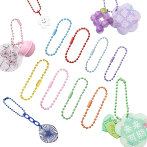Macro detail of colorful iron bead chains with assorted charms and acrylic pendants