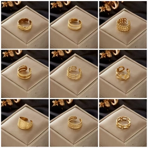 Nine diverse gold-plated stainless steel open rings displayed on champagne jewelry boxes