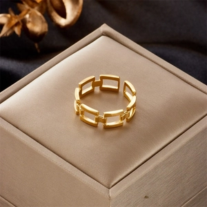 Detail of adjustable gold-plated chain-link ring displayed on luxury jewelry box and silk