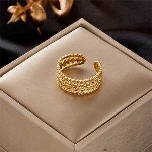 Macro detail of a gold-plated adjustable ring featuring wheat leaf patterns and bead edges