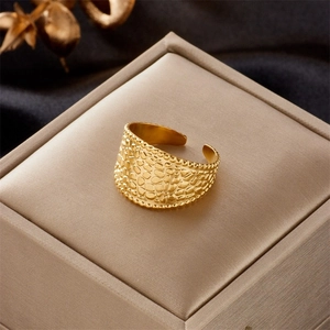 Detail of gold-plated stainless steel wide ring with scales texture and beaded edges