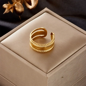 Close-up of golden adjustable open ring with rope texture detail on jewelry box