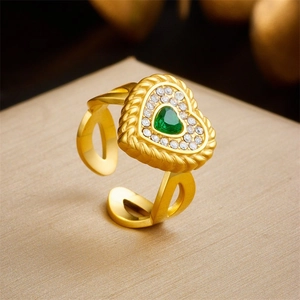 Macro view of gold plated heart ring with green zircon stone and twisted metal edge