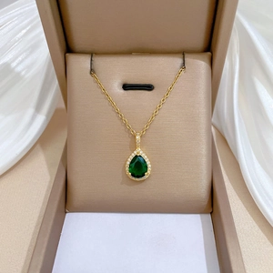 Elegant gold necklace featuring a pear-cut emerald green gemstone pendant with white diamonds