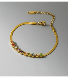 Macro view of gold-plated snake chain necklace with vibrant rainbow zircon gemstones