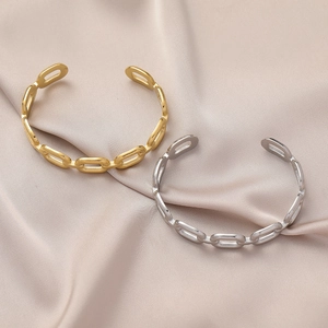 Detail of gold and silver plated chain cuff bracelets on luxury champagne silk background