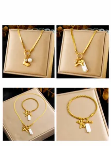 Dettaglio di bracciali con fiocco dorato e collane con perle a cuore su velluto
