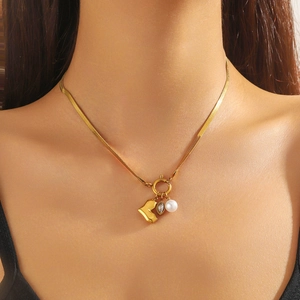 Collana a catena serpente dorata con pendente a cuore e perla indossata da modella