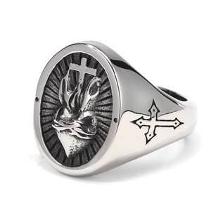 Detailed view of silver signet ring with engraved sacred heart and cross patterns
