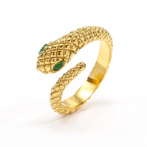 Primer plano de un anillo de serpiente dorado con ojos de gema verde y textura de escamas