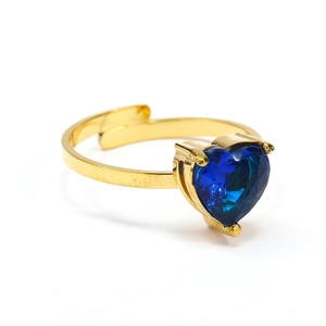 Primer plano de un anillo dorado ajustable con una gema azul en forma de corazón brillante