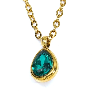 Collier de luxe doré avec pendentif en zircon vert en forme de poire sur fond blanc