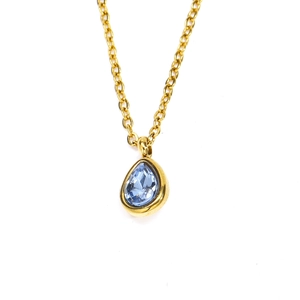 Gros plan d'un collier doré de luxe avec un pendentif en zircon bleu en forme de goutte