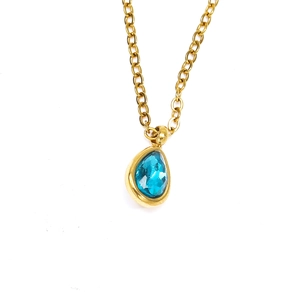 Détail du collier chaîne dorée orné d'un zircon bleu taillé en forme de poire facettée