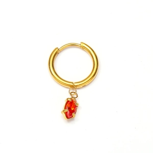 Gros plan détaillé des boucles d'oreilles en or 18 carats avec pendentif zircon rouge