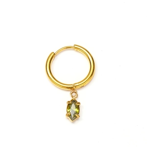 Macro détaillée de boucles d'oreilles créoles dorées avec zircons verts en marquise