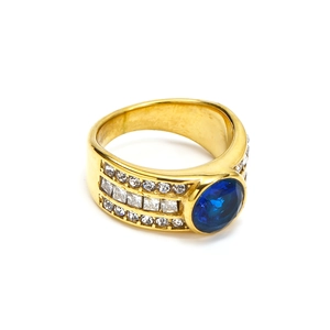 Macro detail of oval blue gemstone ring with pave setting on wide gold band
