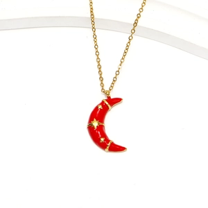 Detailed close-up of 18k gold moon pendant with red enamel and gold star patterns
