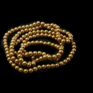 Runde goldene Glasperlen auf Schnur für DIY-Schmuckherstellung auf schwarzem Hintergrund
