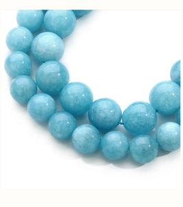 Macro shot of sky blue round semi-precious beads with natural texture and soft lighting
