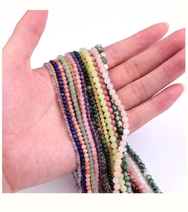 Macro view of multi-colored natural stone beads for DIY jewelry making in a hand