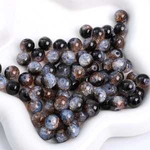 Dettaglio macro di perle tonde in vetro galaxy con glitter metallici e foro centrale