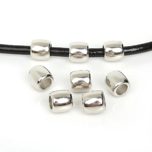 Close-up of shiny silver cylinder CCB spacer beads on black leather cord for jewelry DIY