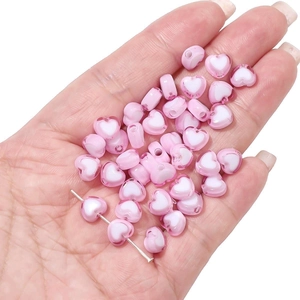 Close-up of pink translucent acrylic heart-shaped beads for DIY jewelry making