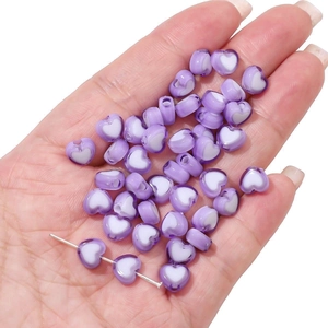 Macro detail of purple and white acrylic heart beads for DIY jewelry making and threading
