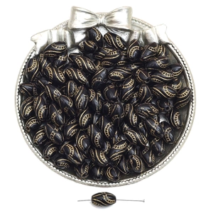 Macro view of vintage French black acrylic beads with gold floral engraving for DIY jewelry