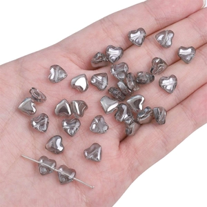 Macro detail of smoke gray translucent heart-shaped glass beads with hole for DIY jewelry