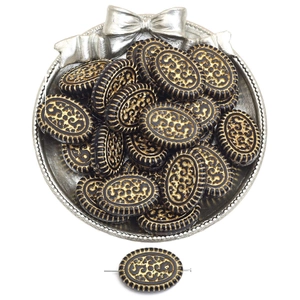 Detailed macro of oval black and gold acrylic beads with vintage filigree for DIY jewelry